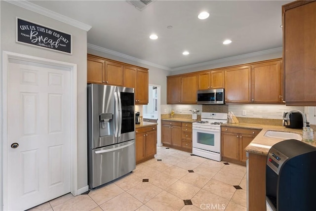 kitchen with brown cabinets, appliances with stainless steel finishes, and a sink