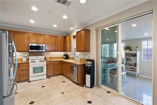 kitchen featuring a sink, brown cabinetry, stainless steel appliances, visible vents, and ornamental molding