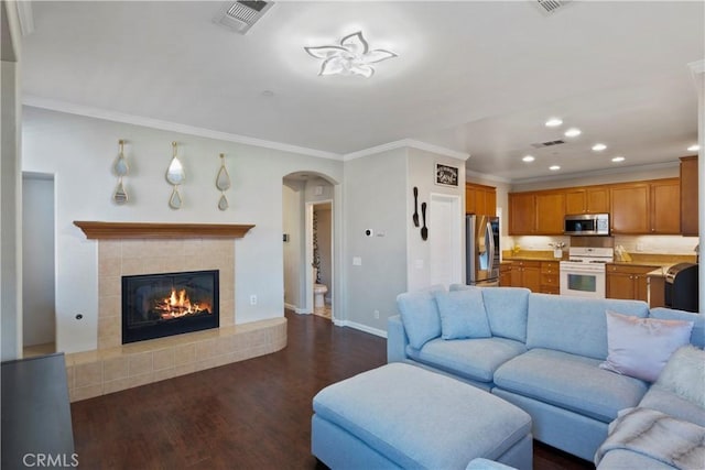 living room with visible vents, arched walkways, dark wood-style flooring, and baseboards