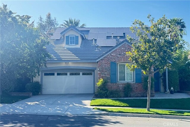 24939 Coral Canyon Rd, Corona, CA 92883 - view of front of property with concrete driveway, a garage, roof mounted solar panels, and stone siding