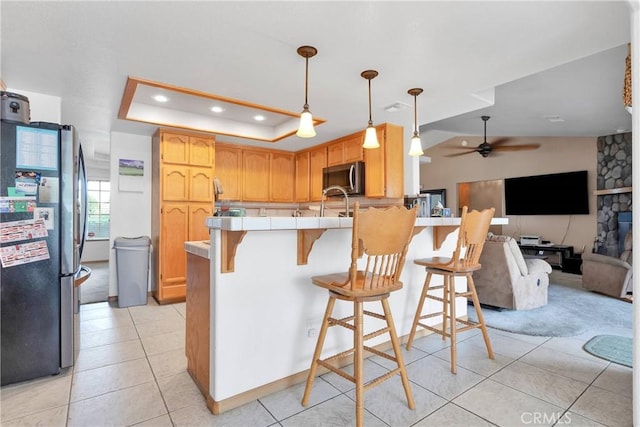 19804 Haida Rd, Apple Valley, CA 92307 - kitchen with a peninsula, light tile patterned flooring, a kitchen bar, a ceiling fan, and stainless steel appliances