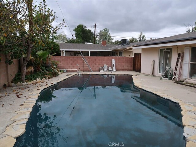 view of swimming pool featuring a fenced in pool, a fenced backyard, a patio area, and cooling unit