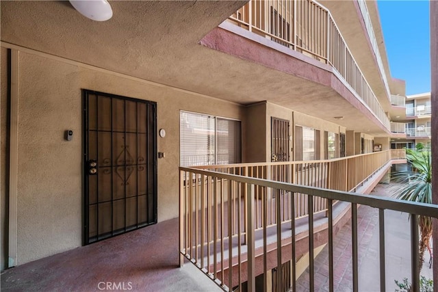 doorway to property featuring a balcony and stucco siding