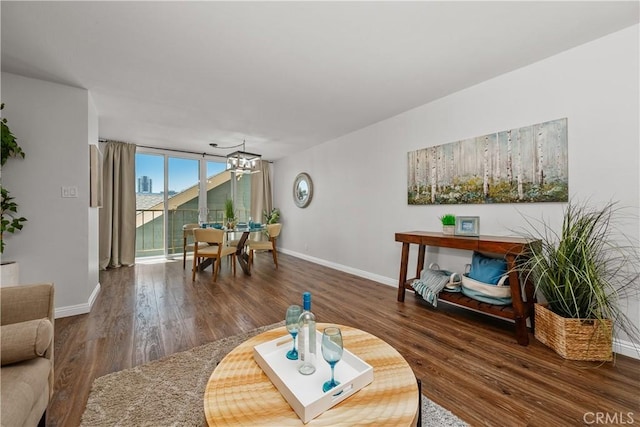 living room featuring baseboards, a chandelier, and wood finished floors
