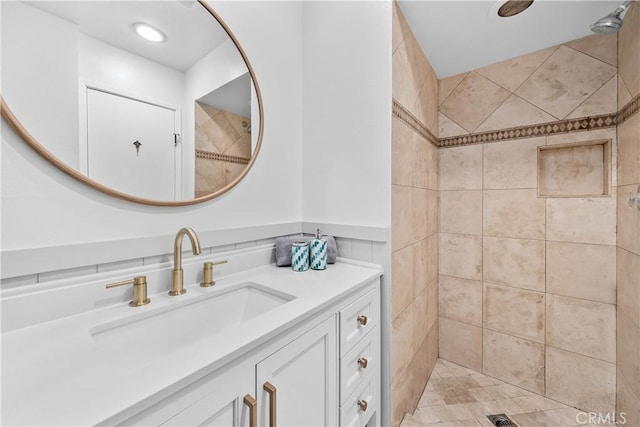 full bath featuring vanity and tiled shower