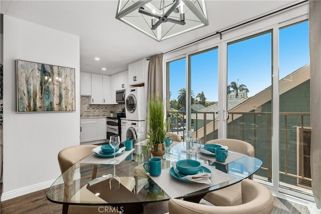 dining area featuring stacked washer and dryer, an inviting chandelier, recessed lighting, baseboards, and dark wood-type flooring