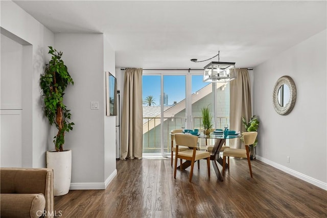 dining room featuring baseboards, a chandelier, and dark wood-style floors