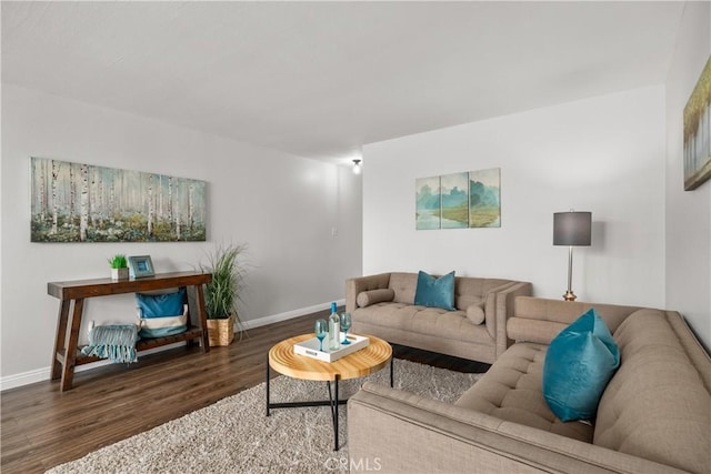 living area with baseboards and wood finished floors