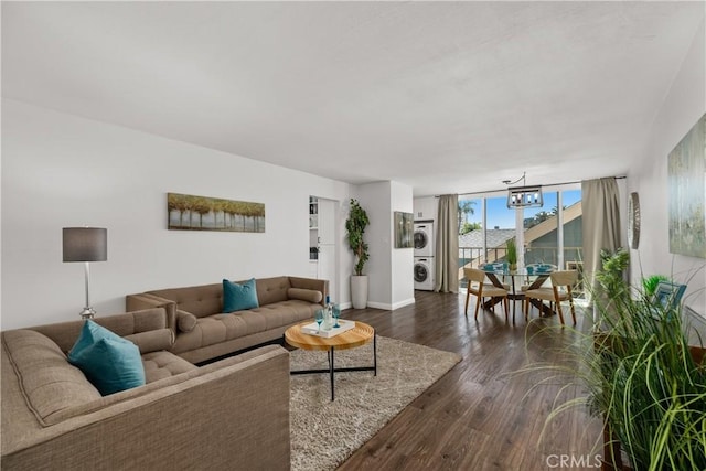 545 Chestnut Ave Unit 202, Long Beach, CA 90802 - living area featuring a wall of windows, baseboards, dark wood-style floors, a chandelier, and stacked washer and clothes dryer