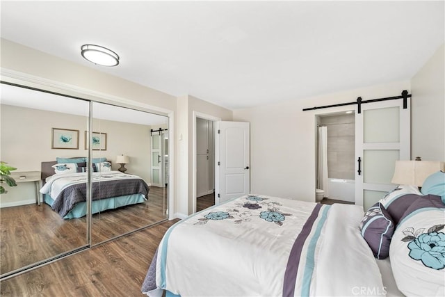 545 Chestnut Ave Unit 202, Long Beach, CA 90802 - bedroom with a barn door, wood finished floors, baseboards, a closet, and ensuite bath