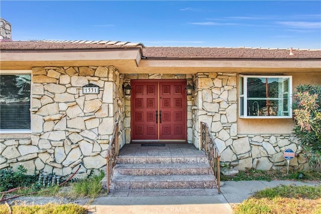 doorway to property with stone siding