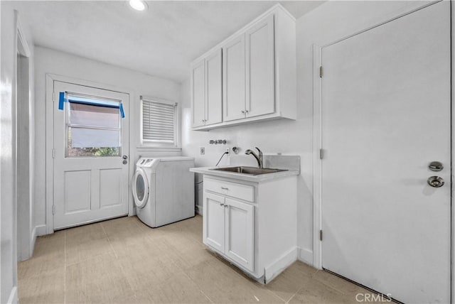 laundry room with cabinet space, separate washer and dryer, and a sink