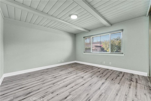 spare room featuring baseboards, beamed ceiling, wood ceiling, and wood finished floors