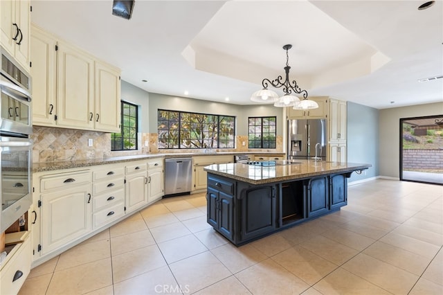 845 N Glendora Ave, Glendora, CA 91741 - kitchen with a raised ceiling, decorative backsplash, stainless steel appliances, and cream cabinetry