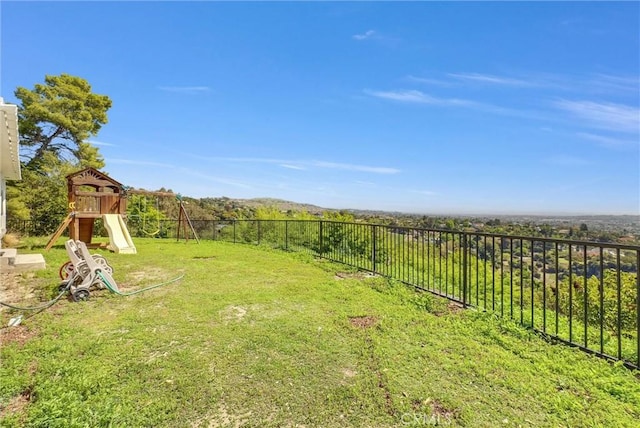 view of yard featuring fence and a playground