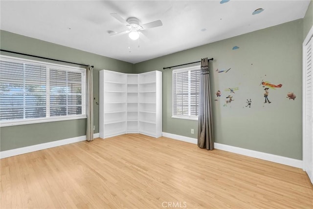 unfurnished room featuring baseboards, a ceiling fan, and light wood-type flooring