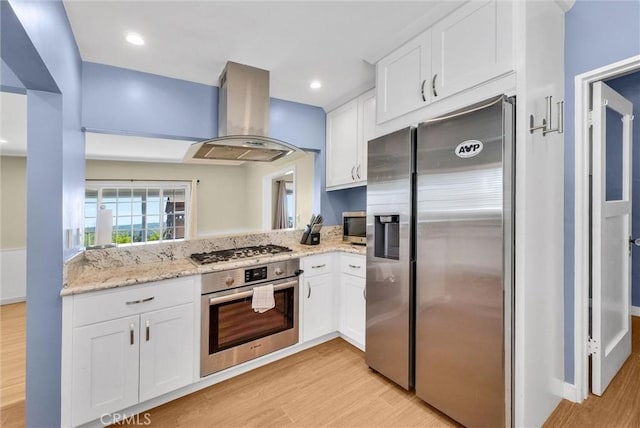 kitchen with stainless steel appliances, white cabinetry, light wood-style flooring, and island range hood
