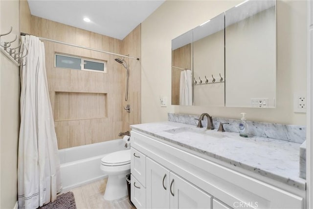 bathroom featuring vanity, shower / tub combo with curtain, and toilet