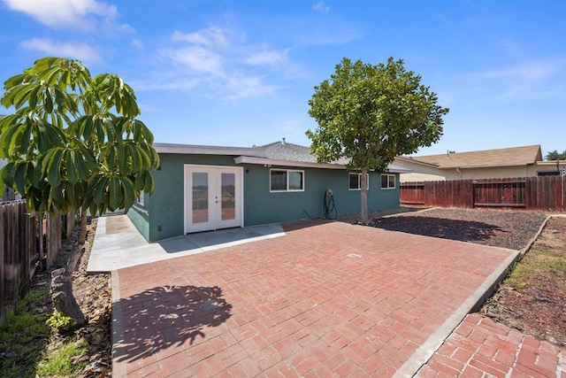 back of house featuring french doors, a patio, stucco siding, and a fenced backyard