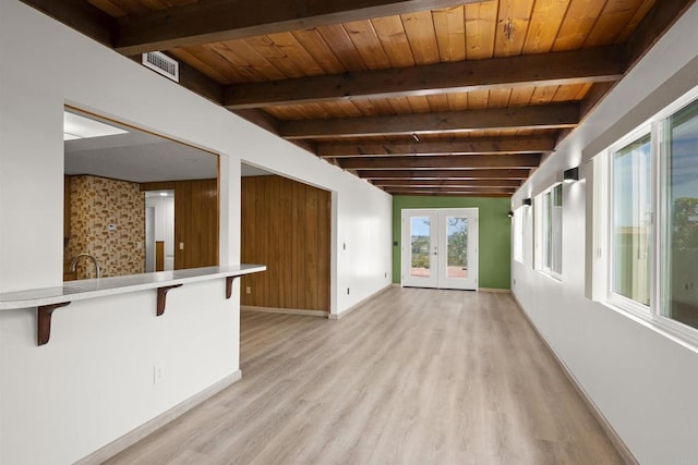 unfurnished living room featuring wood ceiling, beam ceiling, french doors, and light wood-type flooring