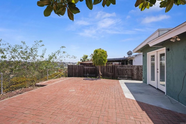 view of patio / terrace featuring fence and french doors
