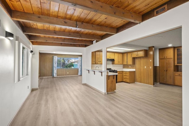 kitchen with baseboards, light wood finished floors, a peninsula, and wood ceiling