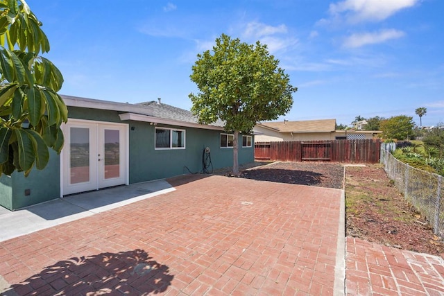 back of property featuring french doors, stucco siding, a fenced backyard, and a patio area