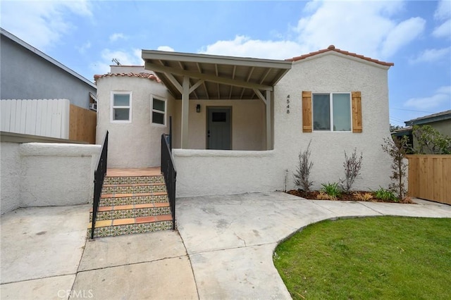 4548 Jade St, Los Angeles, CA 90032 - mediterranean / spanish house with fence, a front lawn, a tile roof, and stucco siding