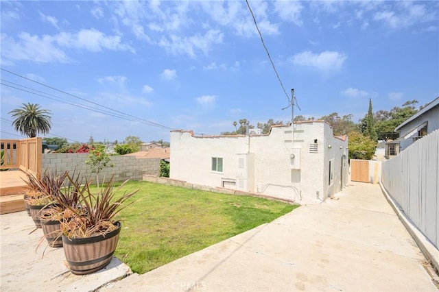 4548 Jade St, Los Angeles, CA 90032 - view of side of home featuring a lawn, a patio, a fenced backyard, and stucco siding