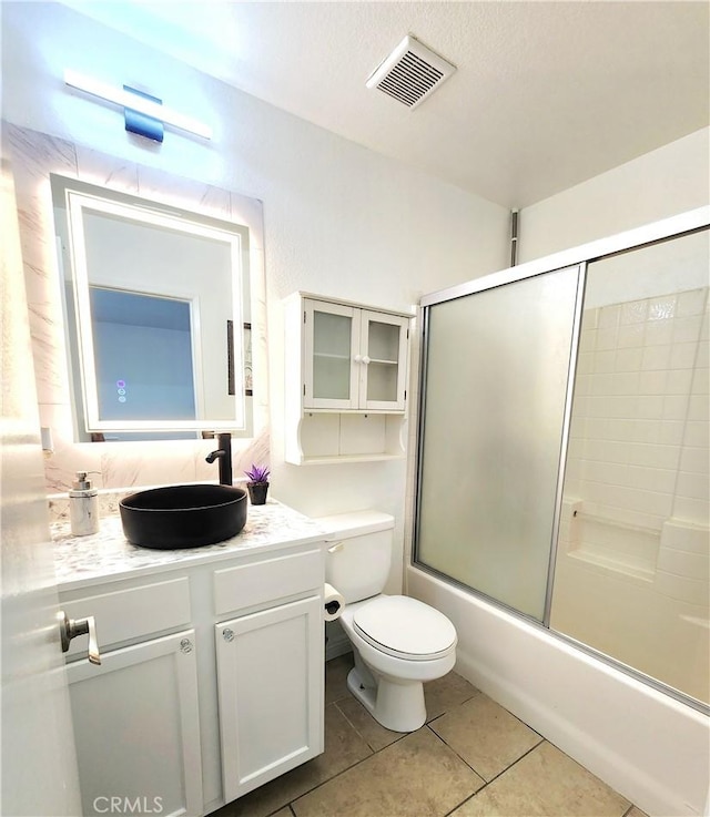 7353 W Ellena W Unit 83, Rancho Cucamonga, CA 91730 - bathroom featuring vanity, toilet, tile patterned floors, and bath / shower combo with glass door