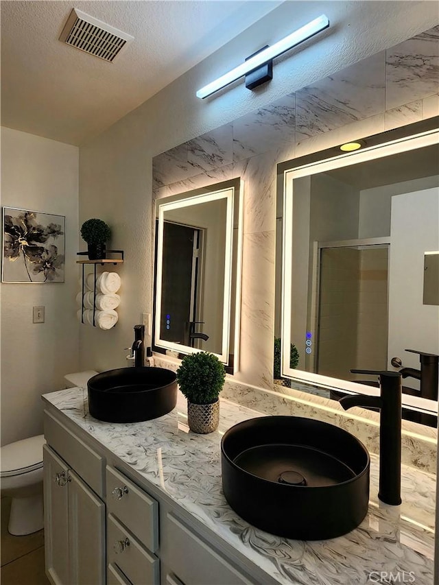 7353 W Ellena W Unit 83, Rancho Cucamonga, CA 91730 - full bath featuring toilet, double vanity, a shower stall, and a textured ceiling