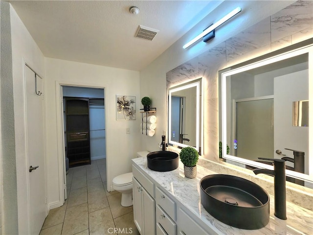 7353 W Ellena W Unit 83, Rancho Cucamonga, CA 91730 - bathroom featuring toilet, double vanity, tile patterned floors, and a stall shower