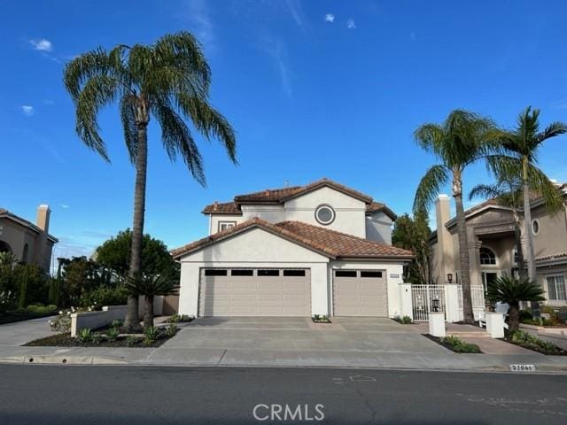 27041 S Ridge Dr, Mission Viejo, CA 92692 - mediterranean / spanish house featuring an attached garage, concrete driveway, stucco siding, and a tile roof