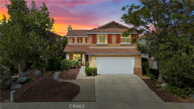 traditional home featuring a tiled roof, concrete driveway, a chimney, and stucco siding
