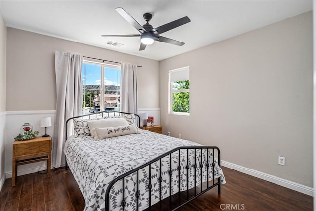 bedroom featuring a ceiling fan, baseboards, visible vents, and wood finished floors