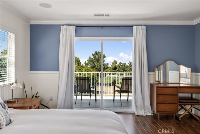 bedroom with crown molding, access to exterior, a wainscoted wall, wood finished floors, and visible vents