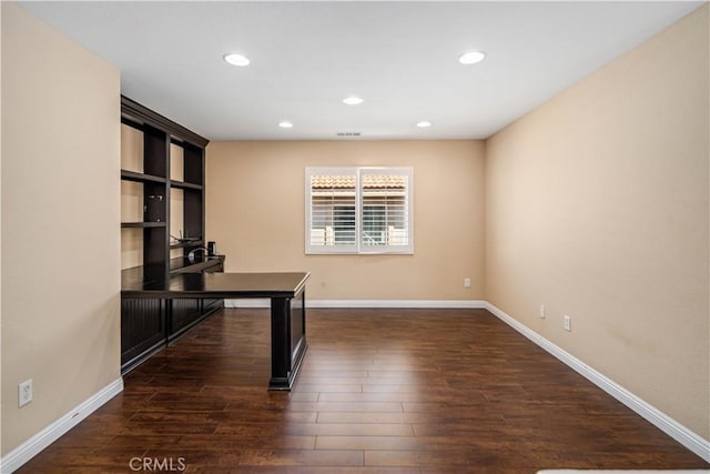 unfurnished office featuring baseboards, recessed lighting, and dark wood-style flooring