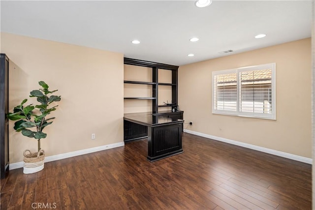 unfurnished office featuring visible vents, recessed lighting, baseboards, and wood finished floors