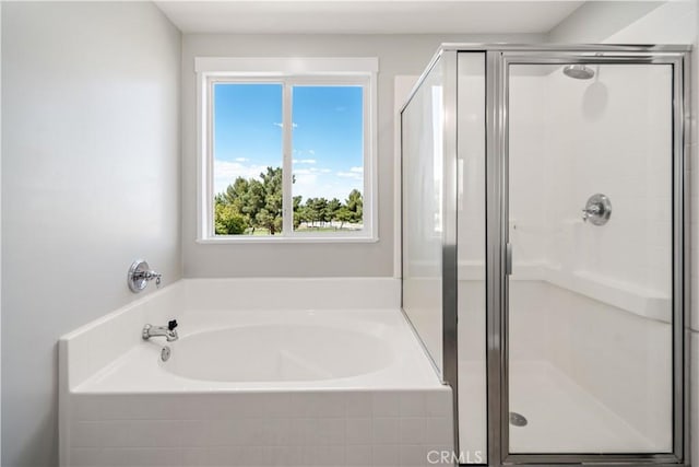 full bathroom with a shower stall and a bath