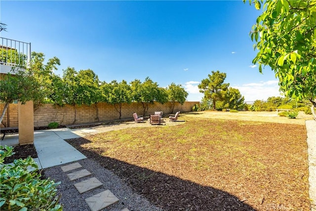 view of yard with fence, an outdoor fire pit, and a patio area