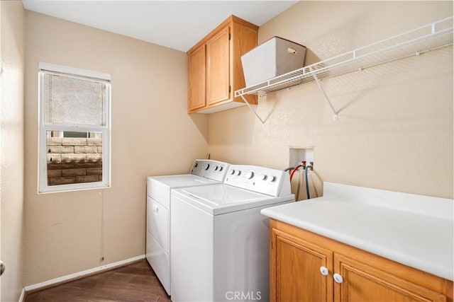clothes washing area with separate washer and dryer, baseboards, dark wood-style flooring, and cabinet space