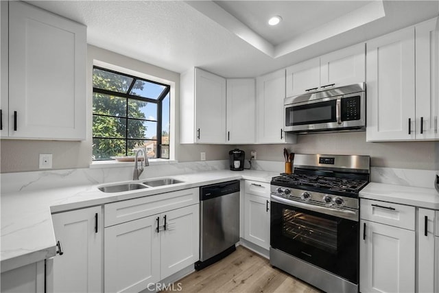 18114 Erik Ct Unit 5131, Canyon Country, CA 91387 - kitchen with appliances with stainless steel finishes, light wood-type flooring, a sink, white cabinets, and recessed lighting