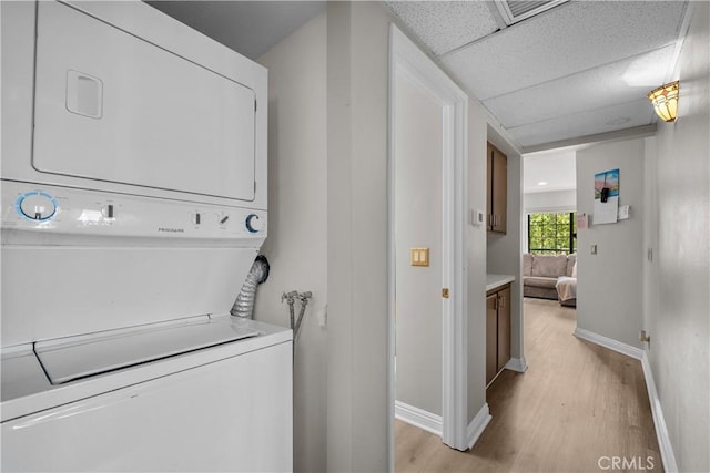 18114 Erik Ct Unit 5131, Canyon Country, CA 91387 - laundry room with estacked washer and dryer, light wood-type flooring, and baseboards