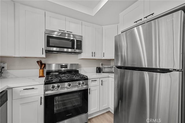 18114 Erik Ct Unit 5131, Canyon Country, CA 91387 - kitchen featuring stainless steel appliances, white cabinets, light stone counters, and light wood-style flooring