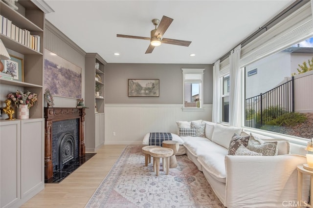 18147 Jupiter Ln, Saugus, CA 91350 - living area featuring light wood-style floors, wainscoting, ceiling fan, recessed lighting, and a high end fireplace