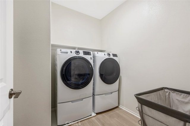 18147 Jupiter Ln, Saugus, CA 91350 - laundry area featuring separate washer and dryer, light wood finished floors, and baseboards
