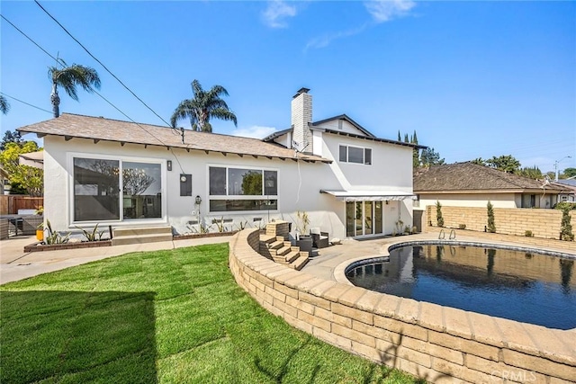 rear view of house featuring a lawn, fence, a patio area, and stucco siding