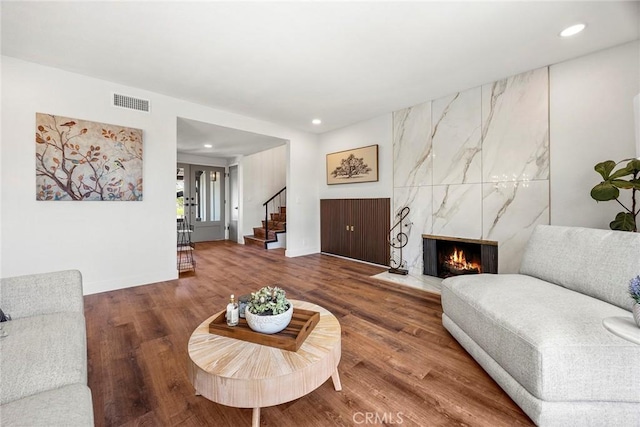 living area with visible vents, recessed lighting, wood finished floors, and stairway