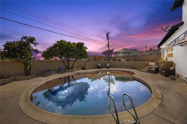 pool at dusk with a fenced in pool, a fenced backyard, and a patio area