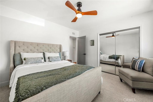 bedroom featuring light colored carpet, a ceiling fan, visible vents, and a closet